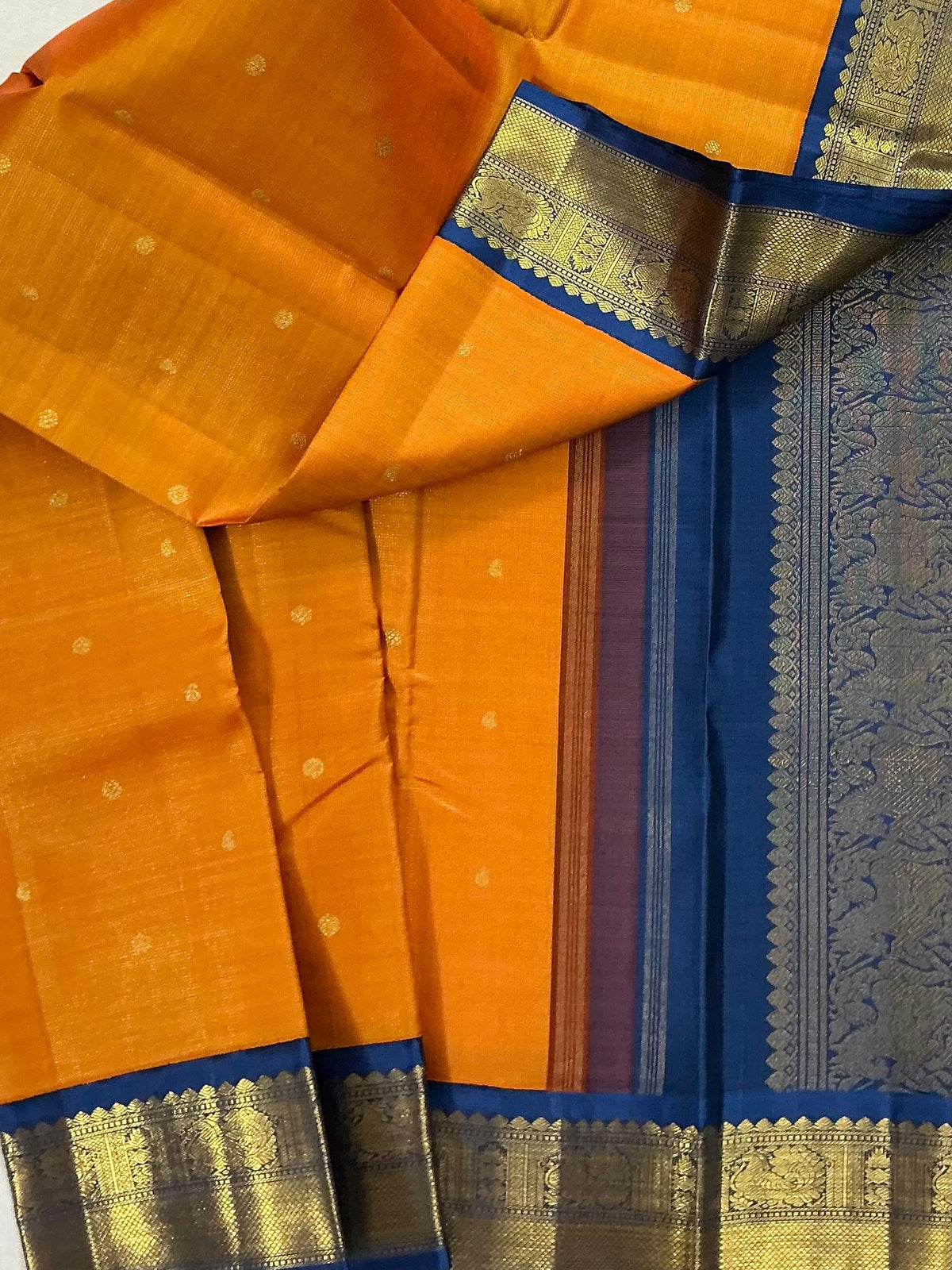 MYTHILI:   Korvai Kanjivaram Silk (Carrot Orange + Burnt blue)